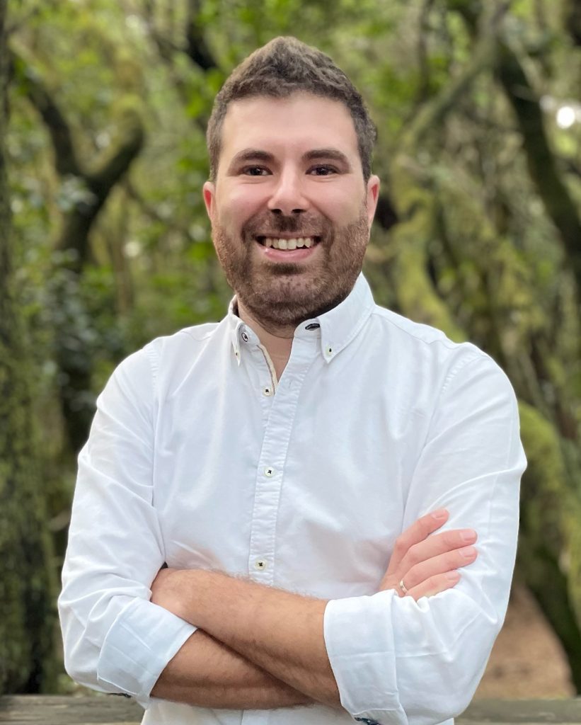 Primer plano de Iván Guerra con un bosque difuminado detrás.